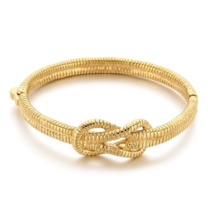 Chic knotted gold metal cuff bracelet with snake chain texture in a minimalist design