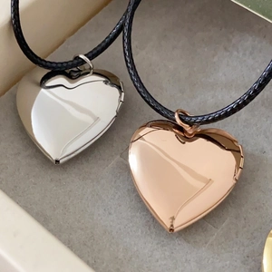 Close-up of heart-shaped floating lockets in polished silver and rose gold finishes