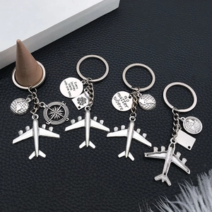 Detailed shot of four silver travel keychains with airplane and passport charms