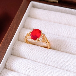 Makroaufnahme eines Vintage-Goldrings mit rotem Edelstein und Diamanten in einer Box