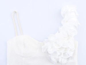 Détail de l'épaule à volants floraux 3D et du tissu en dentelle évidée sur le crop top