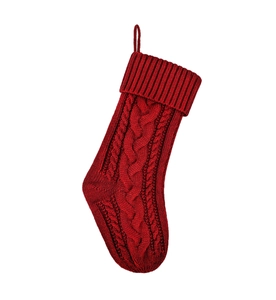 Dettaglio calza di Natale in maglia a trecce rossa con passante per appenderla al muro