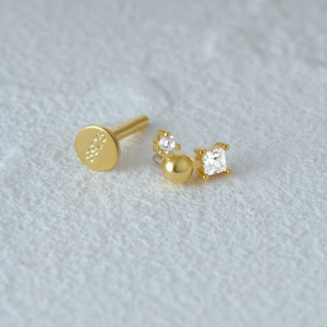 Macro shot of S925 sterling silver gold stud with sparkling cubic zirconia and logo