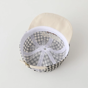 Inside view of baby plaid cap showing Brooklyn embroidery and adjustable metal buckle