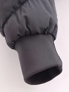 Détail des poignets en maille côtelée coupe-vent sur la manche d'une veste gris foncé