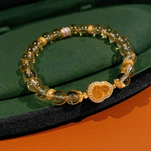 Détail du bracelet en citrine jaune avec pendentif gourde dorée sertie de zircons