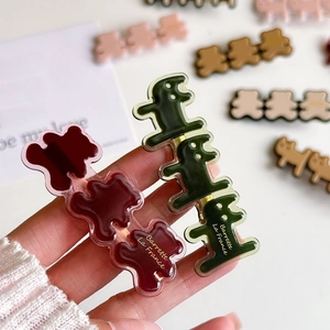 Cute acrylic bear and dinosaur hair clips with golden lettering in rich autumn colors