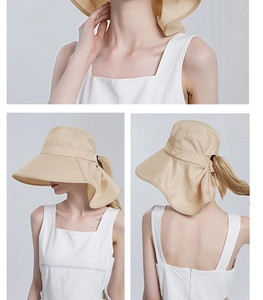 Detail view of khaki sun hat featuring large bow decoration and ponytail hole design