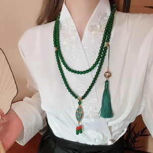 Detail of beaded necklace with cloisonné enamel pendant and green silk tassel decoration