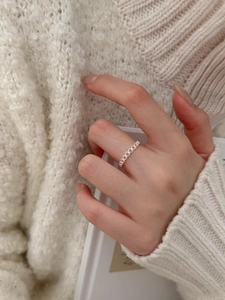 Detailed view of sterling silver hollow chain link ring on a soft knit background