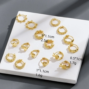 Set of gold earrings with star, rabbit, and twisted rope designs on a display stand