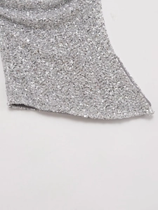Dettaglio macro della trama di paillettes argento fitte sul top a fascia sexy da donna
