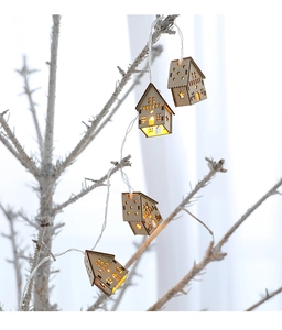 Close-up of wooden house-shaped LED string lights with warm glow on white branches