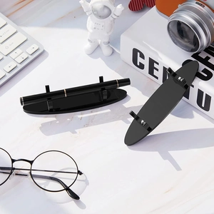 Modern black acrylic pen holder and desk stationery display stand on marble desk