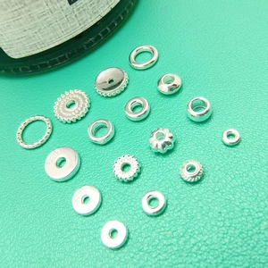 Various 925 silver plated spacer beads in floral and ring shapes on green background