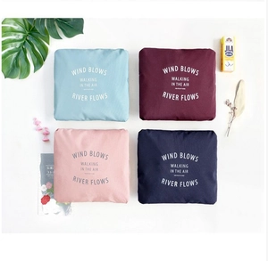 Flat lay of four colorful foldable travel organizer bags in blue and red nylon fabric