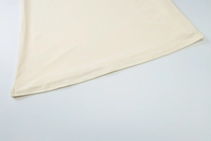 Detailed view of beige knit fabric texture and double-stitched hem on the summer set