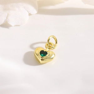 Detailed macro of 18k gold plated heart pendant with green zircon for jewelry DIY