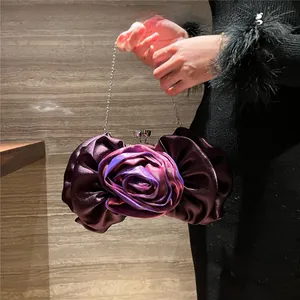 Close-up of three-dimensional rose flower evening bag in magenta silk with metal chain