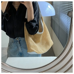 Mirror selfie showing the woven straw beach tote bag with white faux leather trim