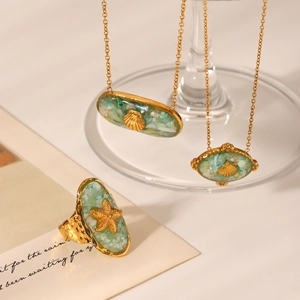 Detail view of gold starfish and shell necklaces with turquoise inlay and matching ring