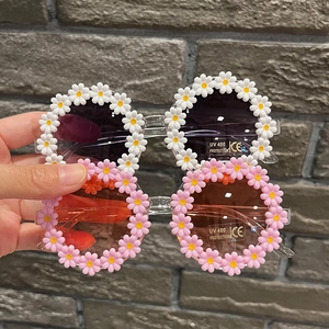 Close-up of daisy-shaped kids sunglasses showing UV400 and CE certification marks
