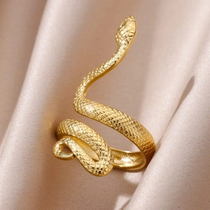 Vintage gold snake ring featuring textured scales on a silk background in close-up view