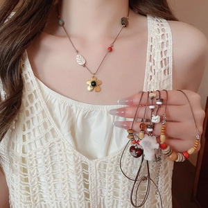Détail du collier ethnique et des bracelets de perles avec perles en bois et pendentif