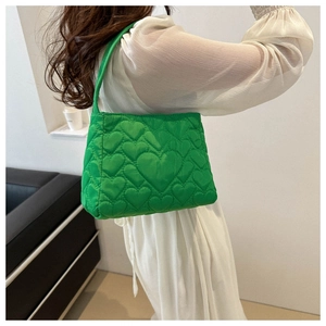 Détail du sac cabas vert vif avec surpiqûres en forme de cœur et texture matelassée
