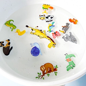 Macro view of colorful waterproof animal stickers floating in water for kids' bath time fun