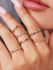Detail of colorful zircon stackable rings in 18K gold plating worn by a model