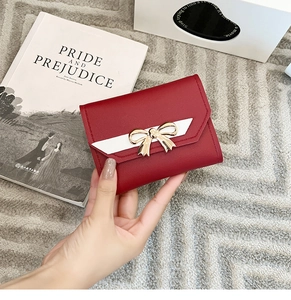 Deep red short wallet for women featuring a golden bow and elegant white chevron detail