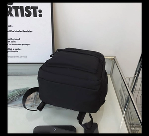 Detail view of the black minimalist backpack with adjustable straps and durable nylon fabric