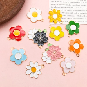 Macro detail of colorful enamel daisy flower charms with metal loops for DIY jewelry