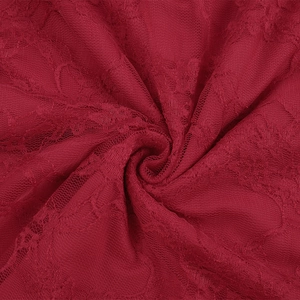 Close-up of dark red floral lace fabric showing intricate mesh texture and soft draping