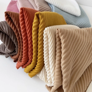 Close-up of pleated solid color scarves showing diagonal twill texture and rich fabric details