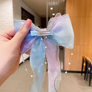 Detailed shot of gradient blue gauze bow hair clip with elegant hanging pearl chains