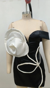 Détail d'une robe bustier en satin avec grande fleur 3D et broderie de perles raffinée