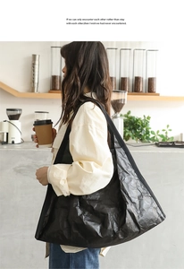 Close-up of black oversized tote bag featuring unique wrinkled texture and wide strap