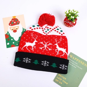 Detail of Christmas knitted hat with pom-pom, reindeer patterns and festive holiday decor