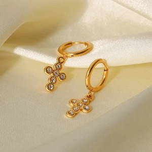 Detail of 18K gold titanium steel hoop earrings with crystal-encrusted cross pendant