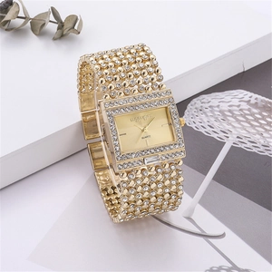 Detailed close-up of a gold quartz watch featuring a crystal-set bezel and a square dial