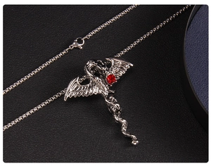 Détail macro du pendentif dragon gothique avec cristal rouge et finition argent vieilli