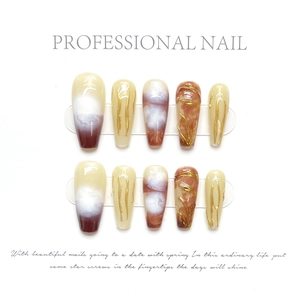 Close-up of long coffin press-on nails with marble texture and 3D gold wire accents