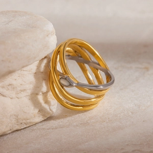 Artistic multi-layer entwined gold and silver snake ring on natural stone background