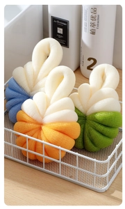 Dettaglio di morbide spugne da bagno a forma di zucca in un cestino di metallo bianco
