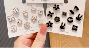 Detail of assorted pearl safety pins and brooches in black and white styles