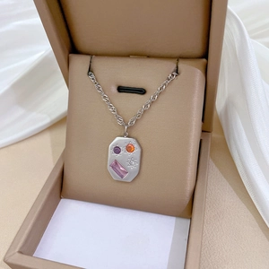 Close-up of silver titanium steel necklace with colorful gems in a jewelry box