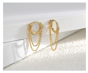 Detail of 18K gold chain tassel hoop earring with micro-set zircon on white steps