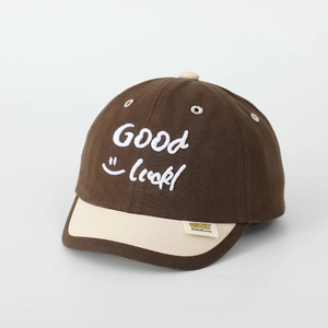 Detail of embroidered smile face and Good Luck lettering on a kids baseball cap